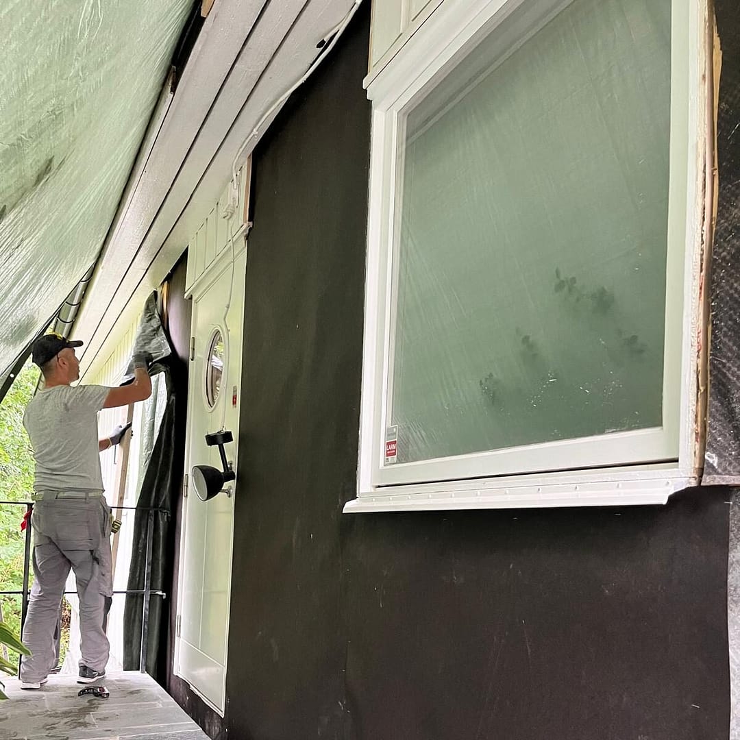 Arbetare som förbereder fasaden under renoveringsarbete på ett hus i Lidingö