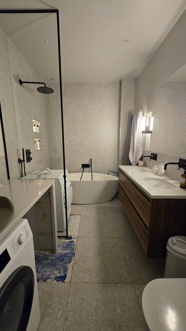 Badrum med frilagda golvplattor och tecken på felaktigt utförande efter en oberoende besiktning i en bostadsrätt