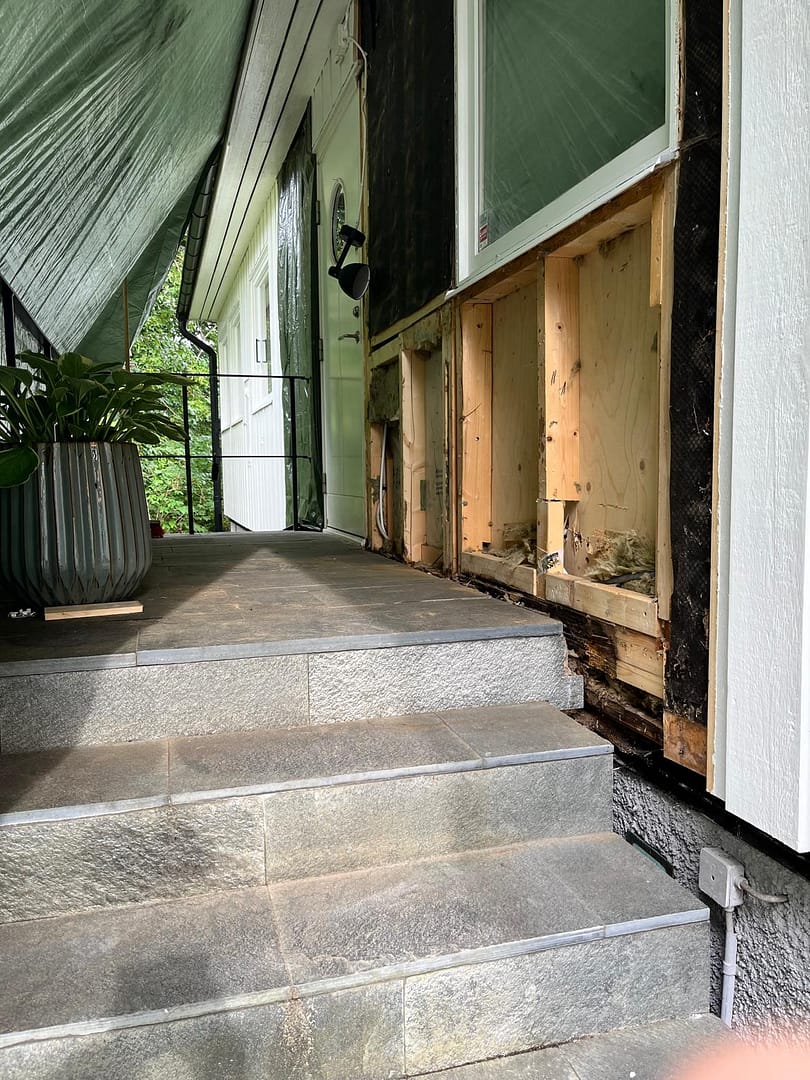 Exponerad fasad efter borttagning av panel vid entré, husrenovering på Lidingö – fasadunderhåll och fastighetsförvaltning