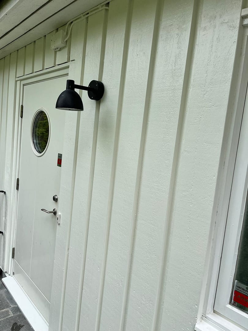 Nyinstallerad fasad och utomhusbelysning vid entré – slutfört renoveringsarbete och fastighetsförvaltning på Lidingö.